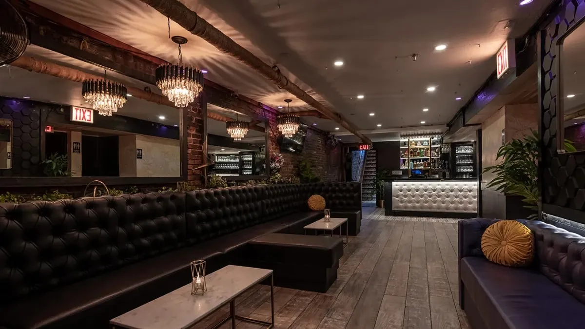 The Party Room and Lounge at Loreley, with long black tufted banquettes, chandeliers and a lit bar